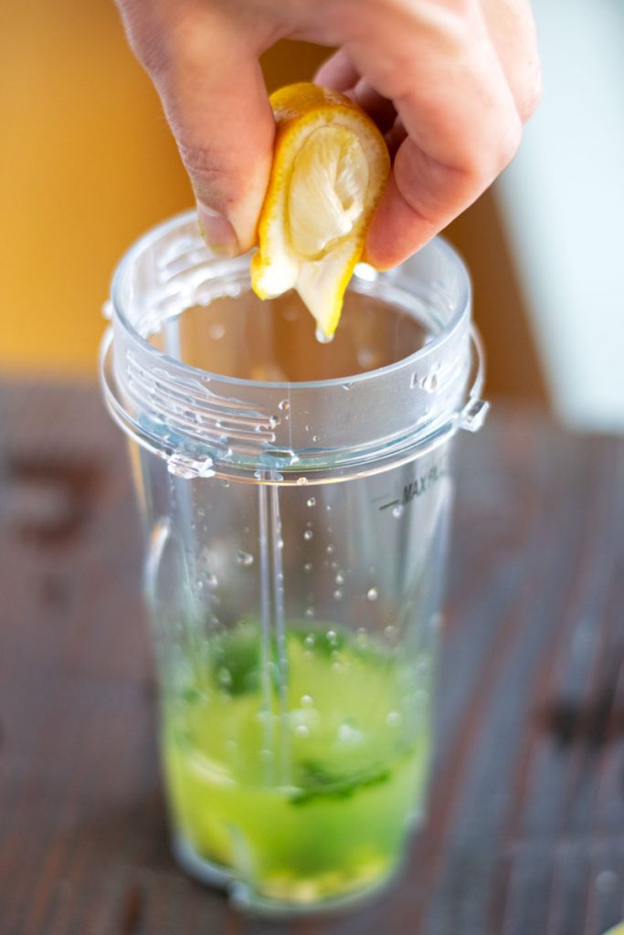 squeezing lemon into green tea shot 