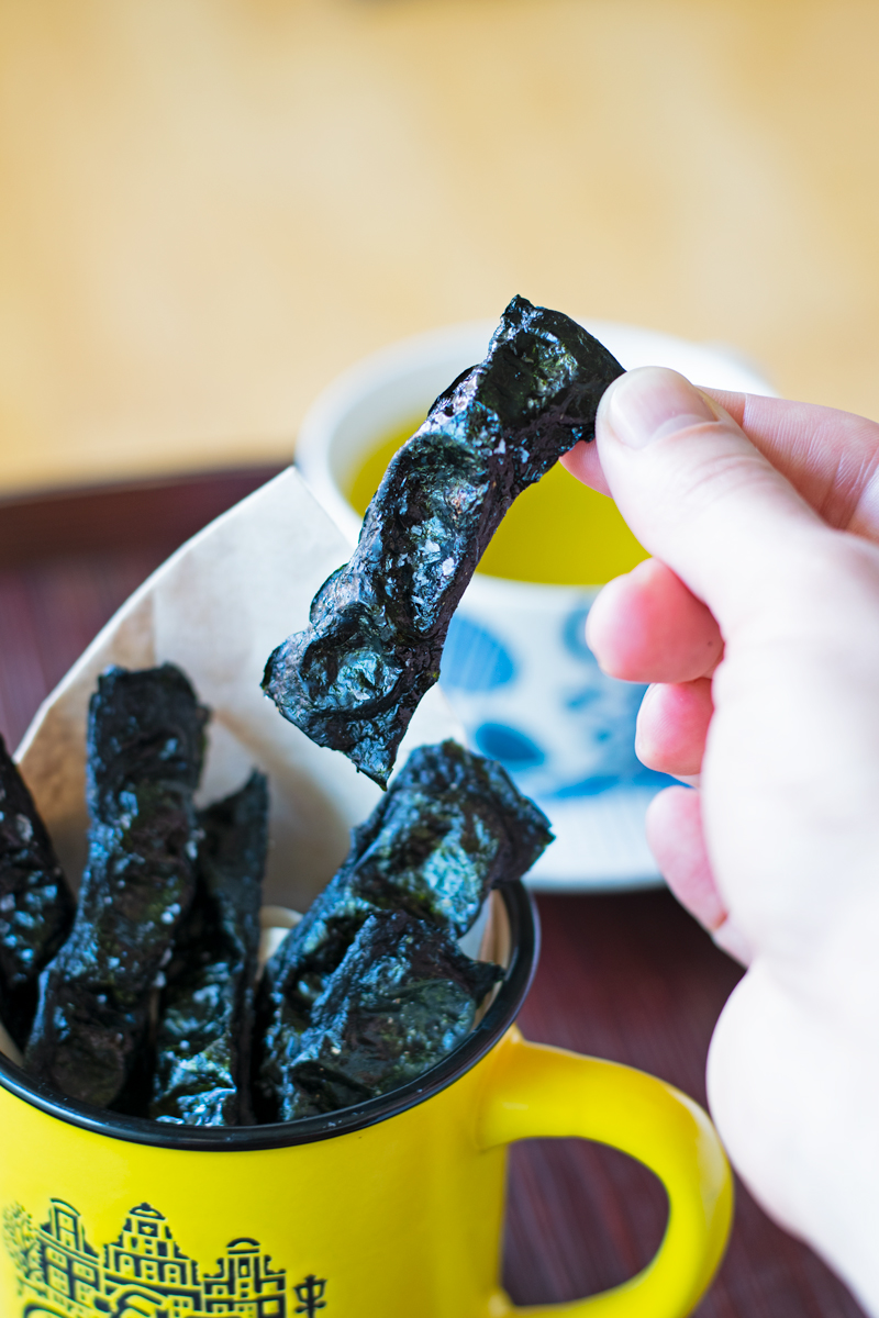 taking our one roasted nori seaweed chip from a cup
