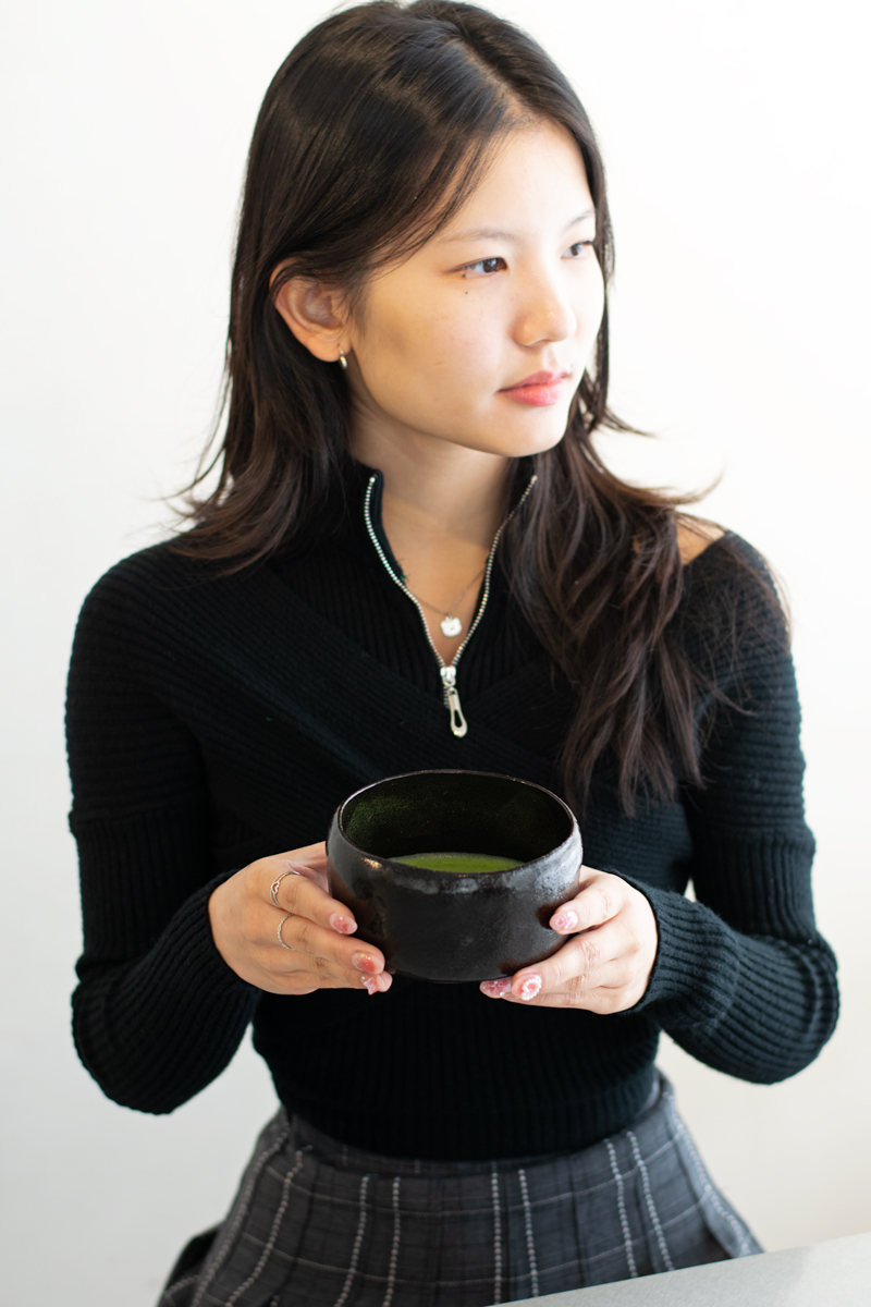 young Asian female holding chawan bowl of matcha