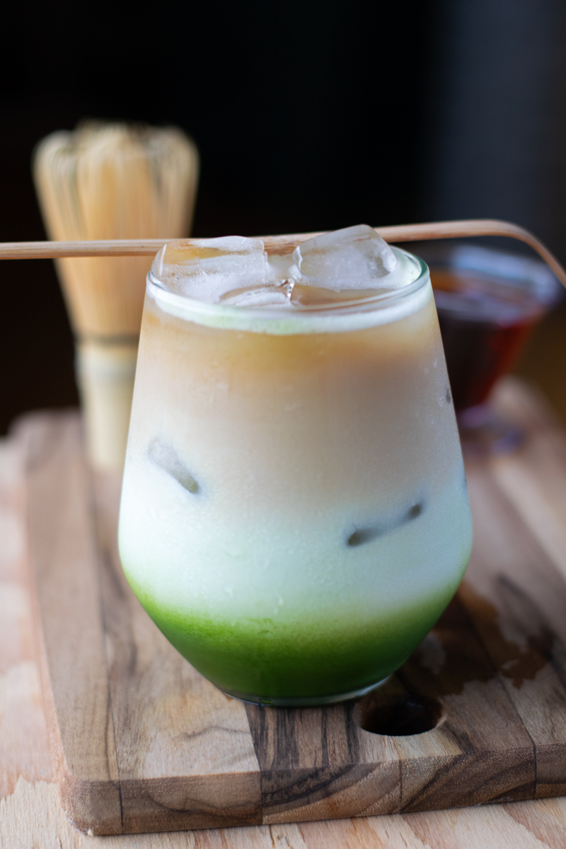 matcha coffee drink with three layers: matcha, milk, and coffee at the top