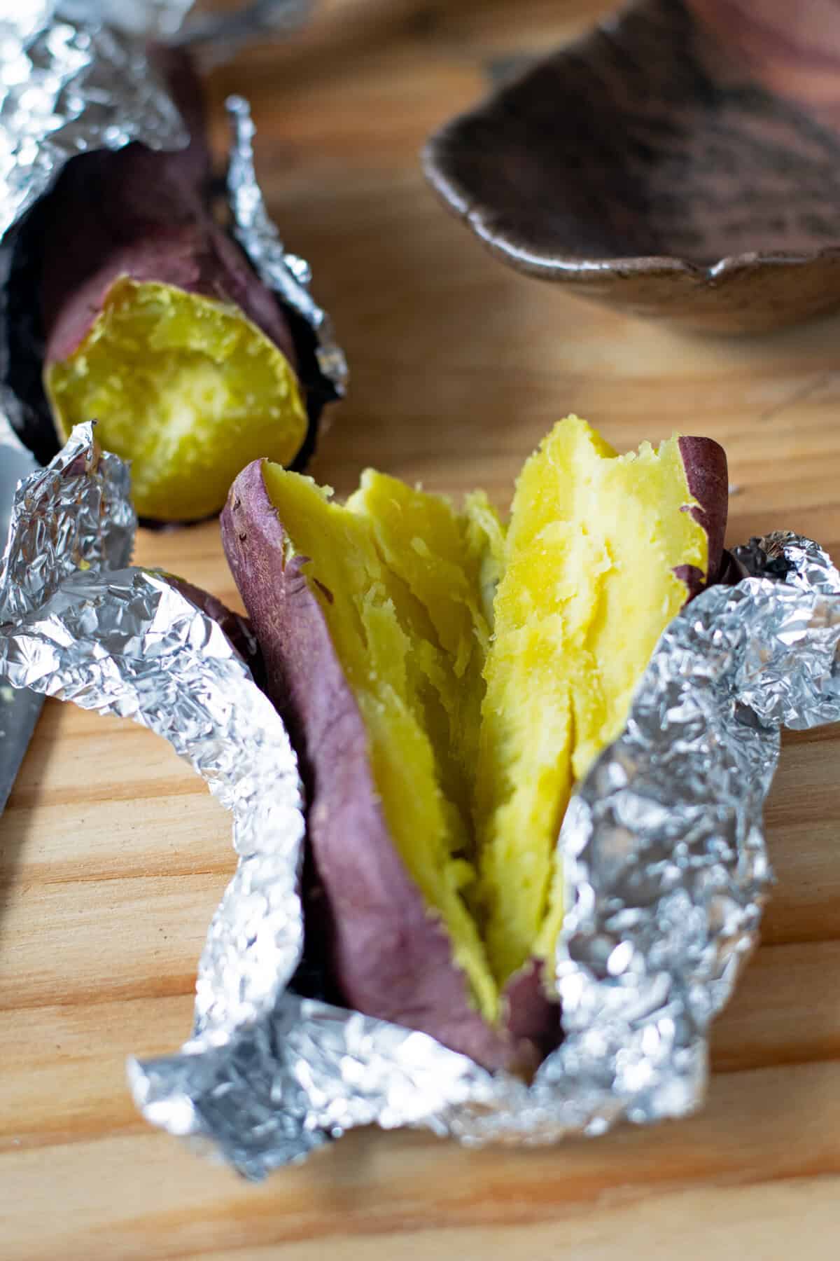 Japanese sweet potato (satsumaimo) wrapped in foil and broken in half to eat.