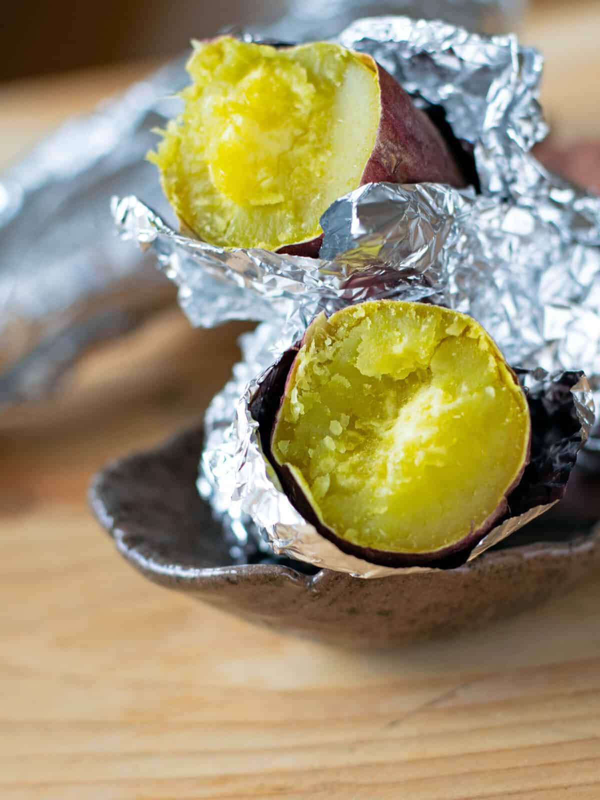 Showing the yellowish flesh of air fried Japanese sweet potato, wrapped in foil.
