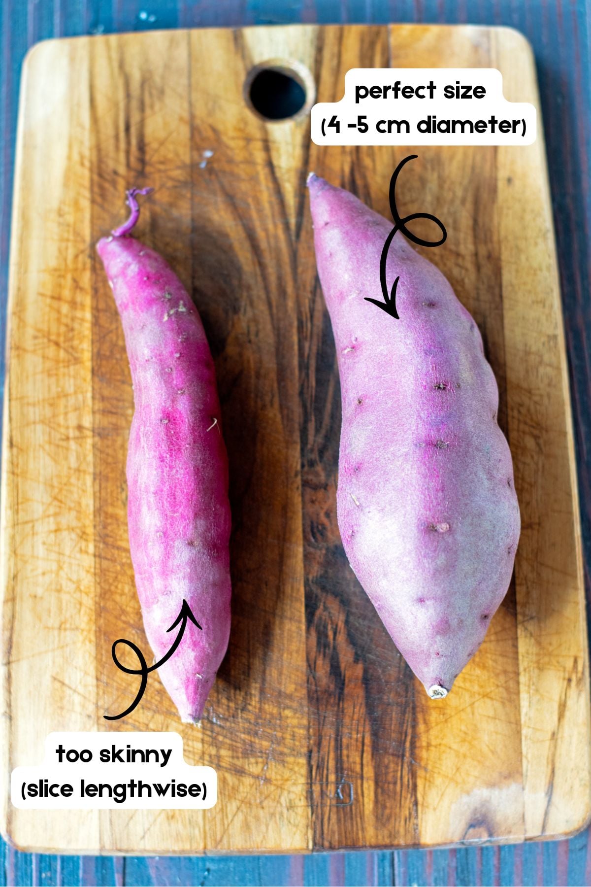 Two Japanese sweet potatoes on a wooden cutting board, one skinny and one wide.