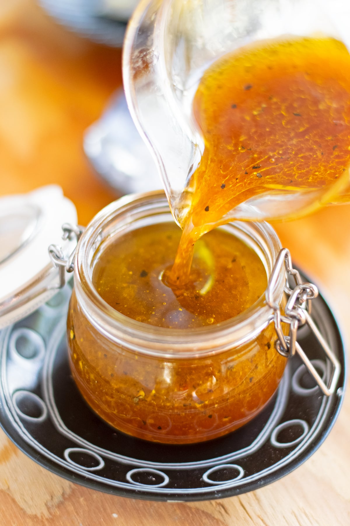 Pouring yuzu vinaigrette into a glass jar.