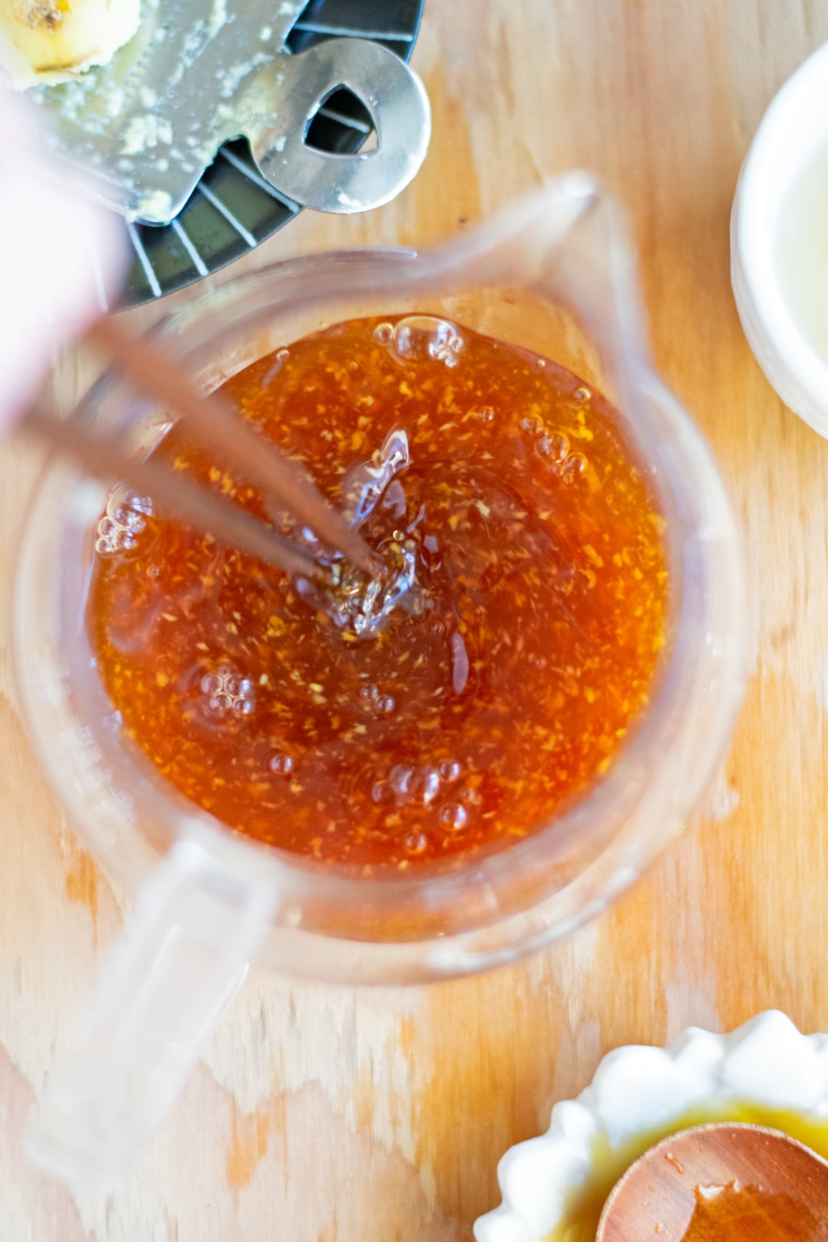 Chopsticks mixing the base of yuzu dressing with freshly grated ginger showing.