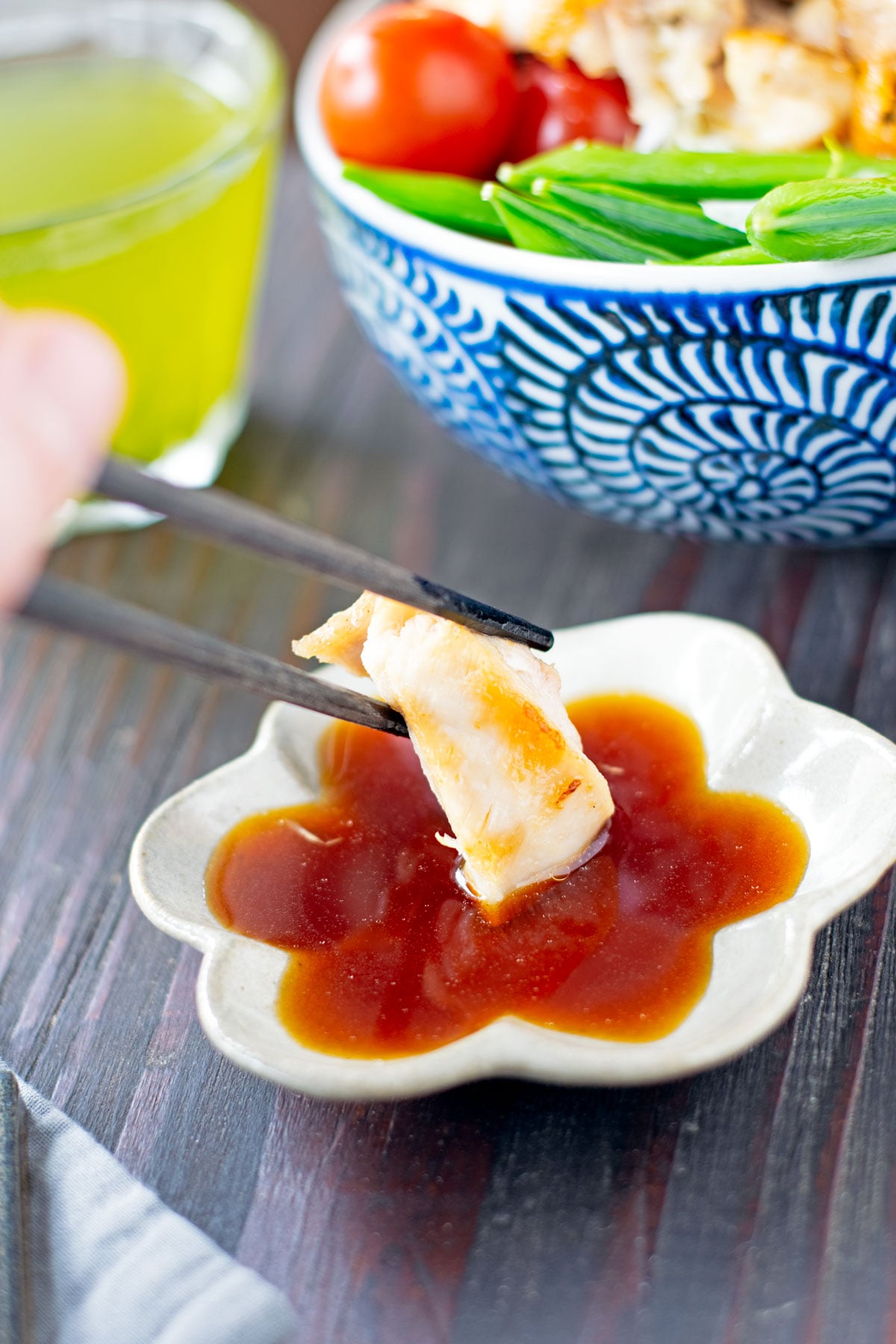 Dipping grilled chicken into yuzu sauce.