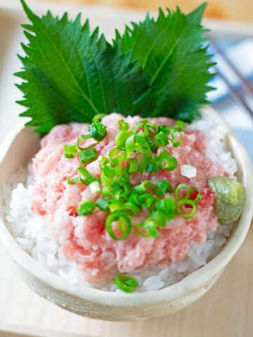 Fresh green shiso leaves served with a negitoro rice bowl, sliced green onions, and wasabi.