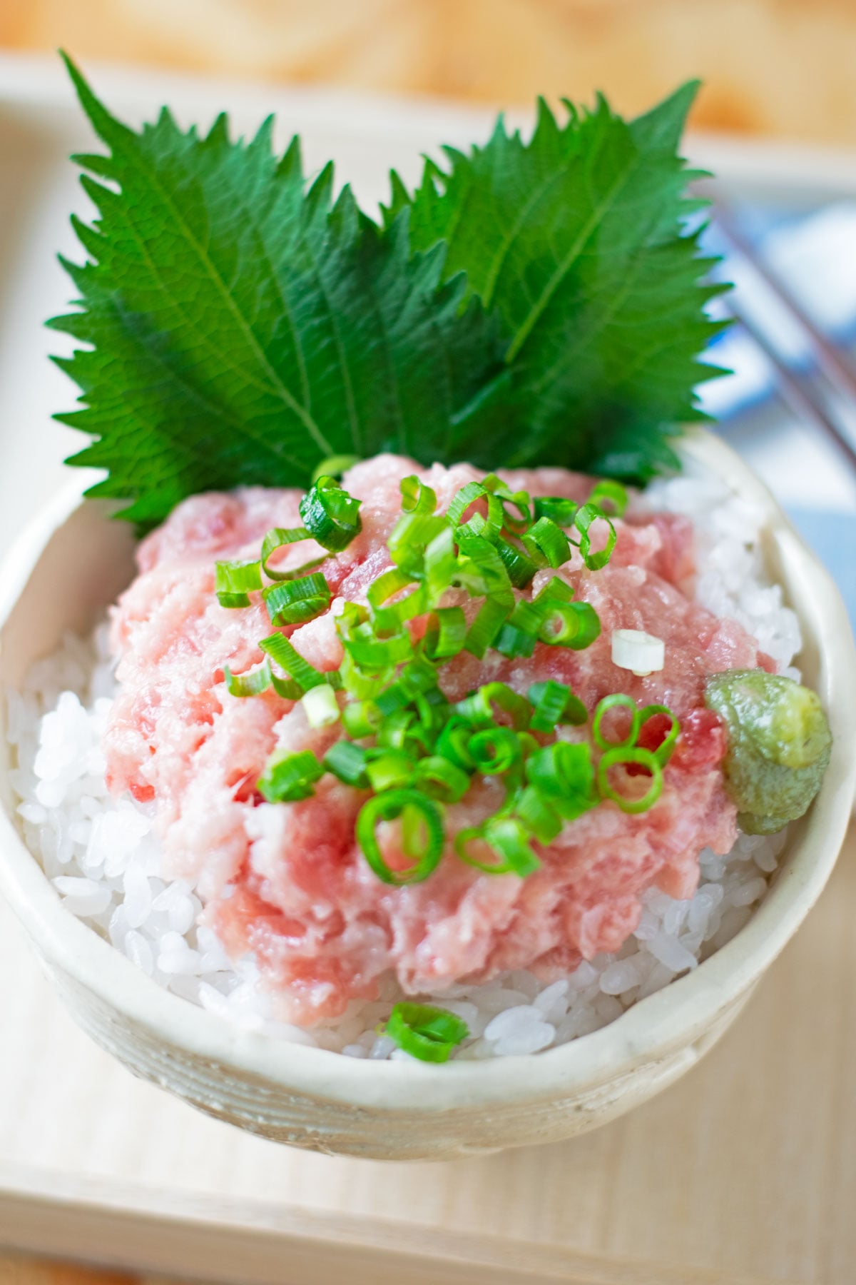 Fresh green shiso leaves served with a negitoro rice bowl, sliced green onions, and wasabi.