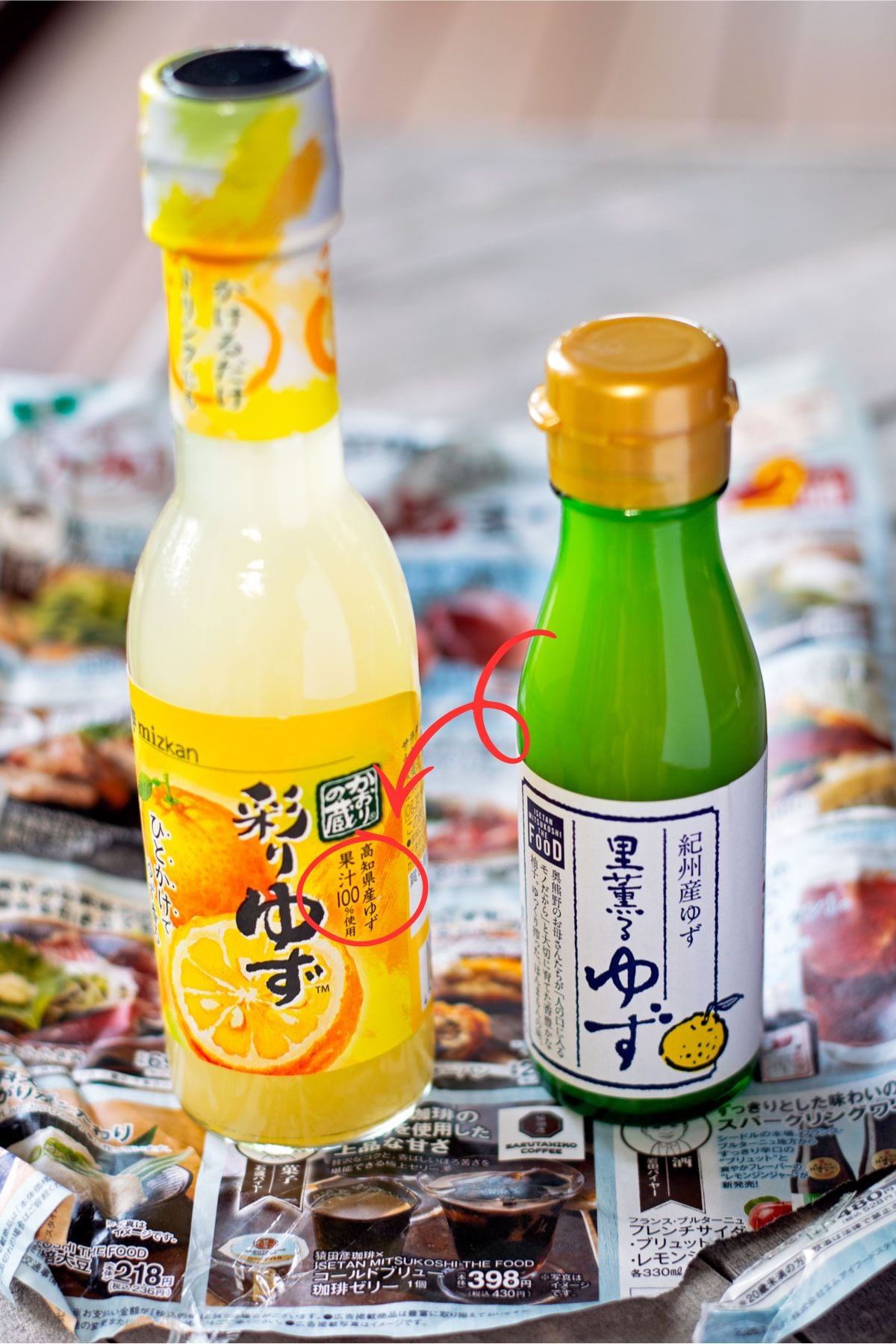 Two bottles of yuzu juice from Japan with a red circle and arrow pointing out "!00% yuzu juice" on the label.