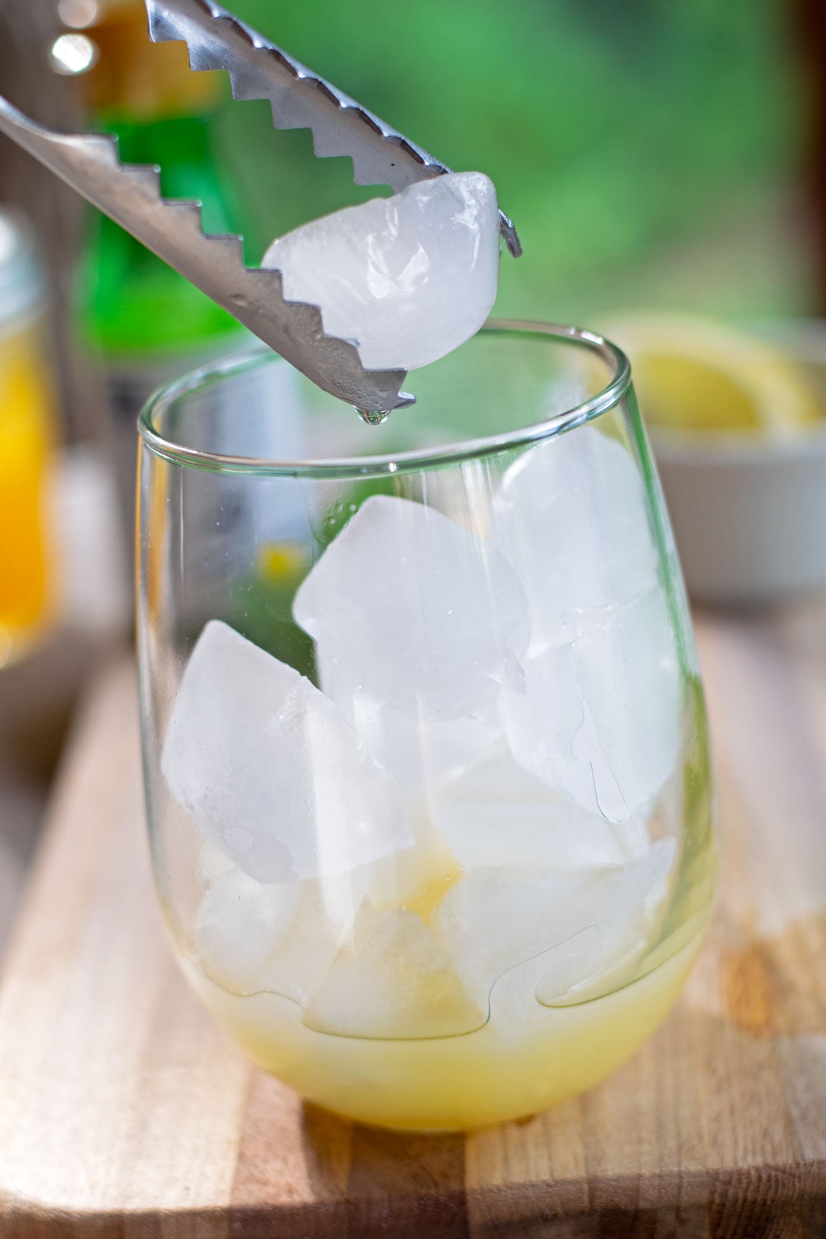 Ice cubes added to a glass of yuzu juice and honey before making a sparkling yuzu mocktail.