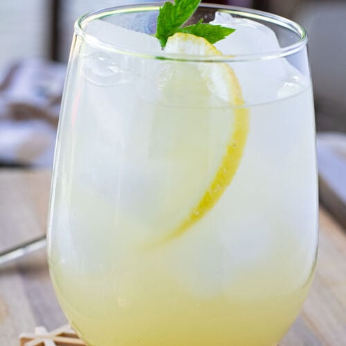 Yuzu mocktail in tall glass garnished with mint and thin lemon slice.