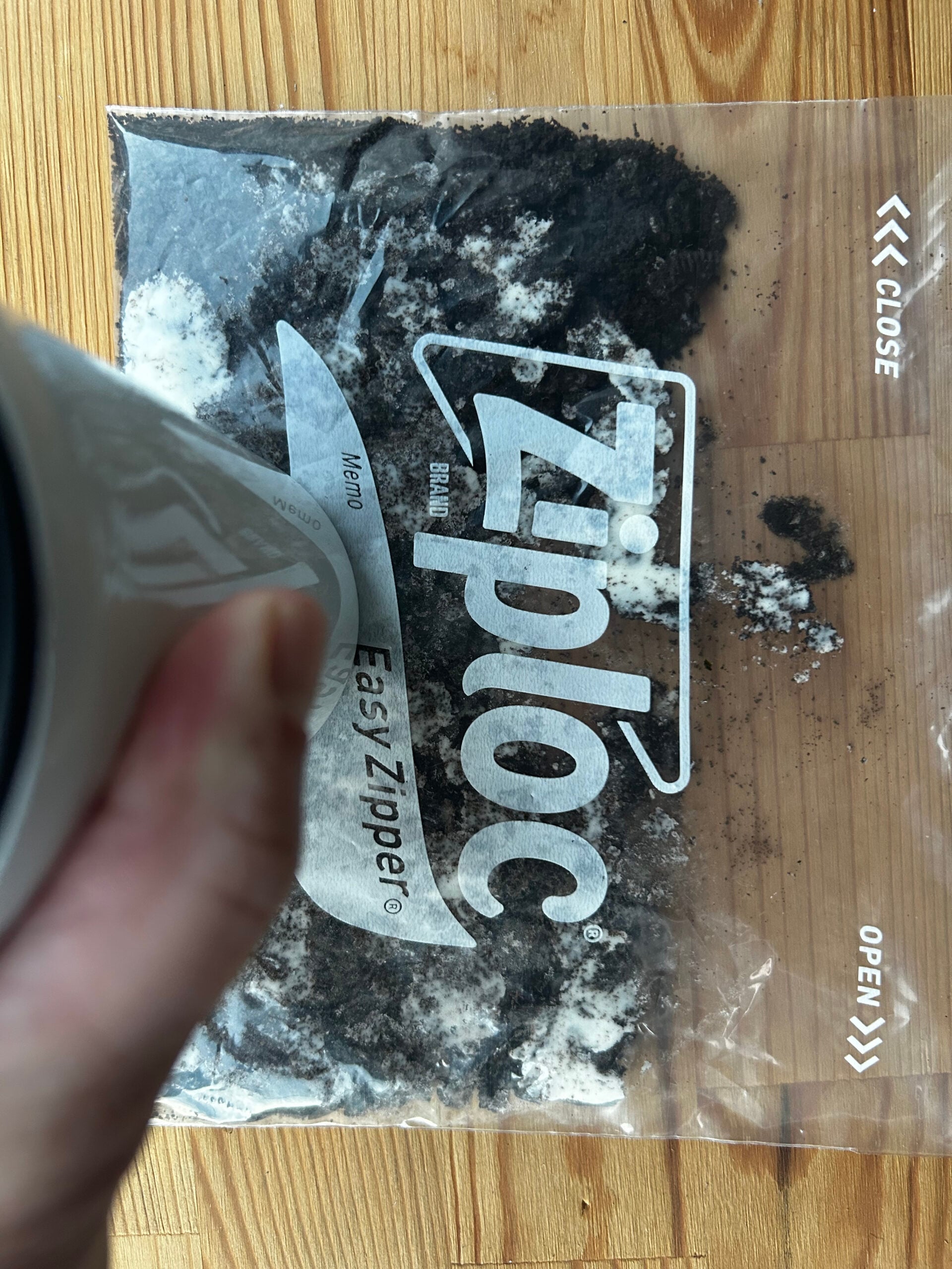 Crushing Oreo cookies in a Ziploc bag with the bottom of a mug.